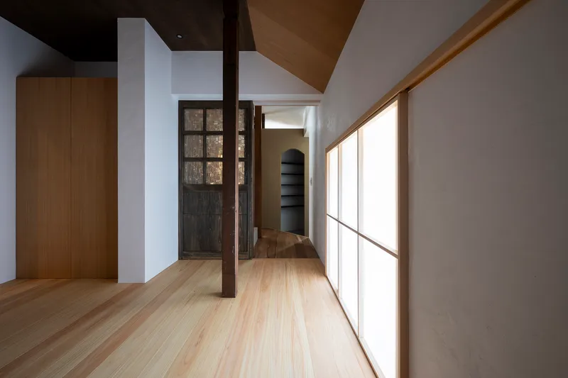 Upper floor hallway with translucent panel wall and exposed timber column at the turn