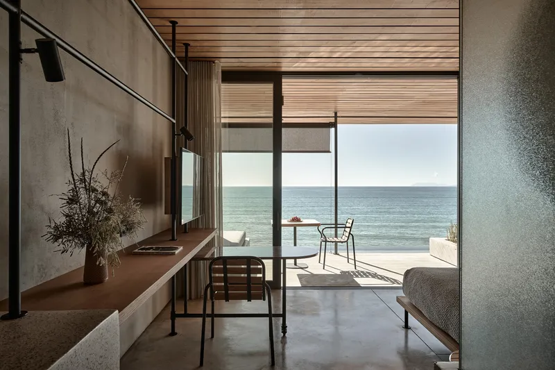 Living area with timber ceiling and polished concrete floor looking toward the sea