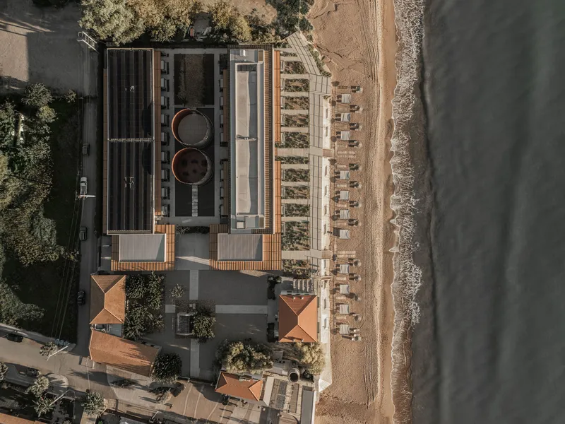 Drone view showing rooftop pools and timber canopy structure along the shoreline