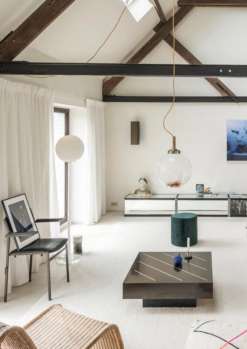 Living room with exposed timber roof trusses and spherical pendant light over carpeted floor