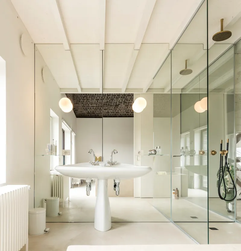 Bathroom with pedestal sink, painted wood beam ceiling, and floor-to-ceiling mirror reflecting the glass shower