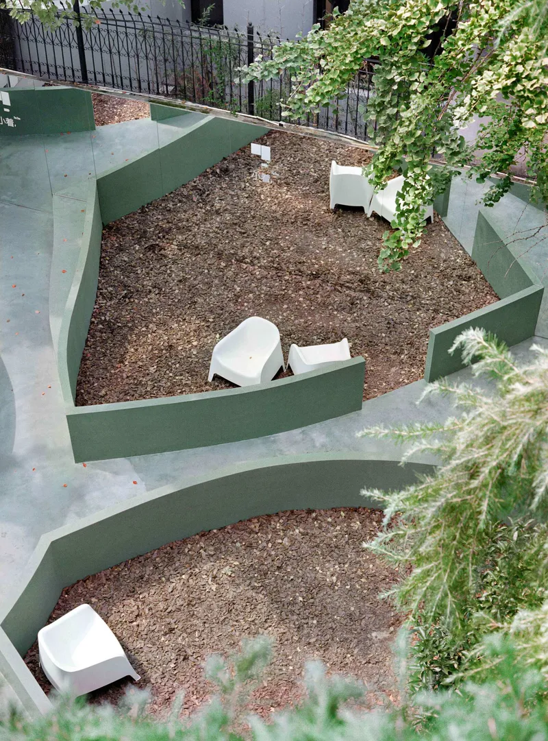 Aerial view of terraced courtyard with green painted steps, gravel beds and climbing vines
