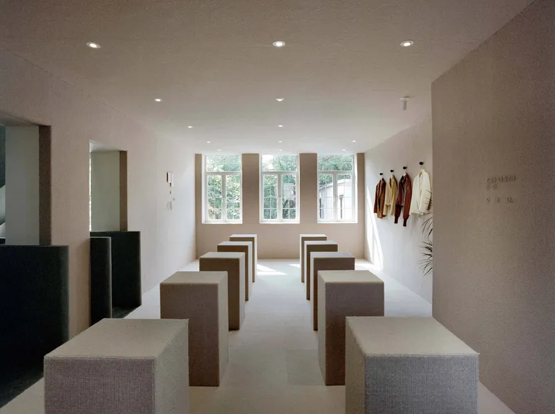 Upper floor gallery with rows of upholstered benches beneath tall windows admitting daylight