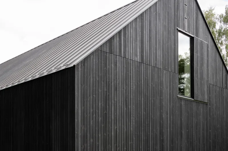 Close-up of the gabled form clad in vertical timber boards with a narrow vertical window