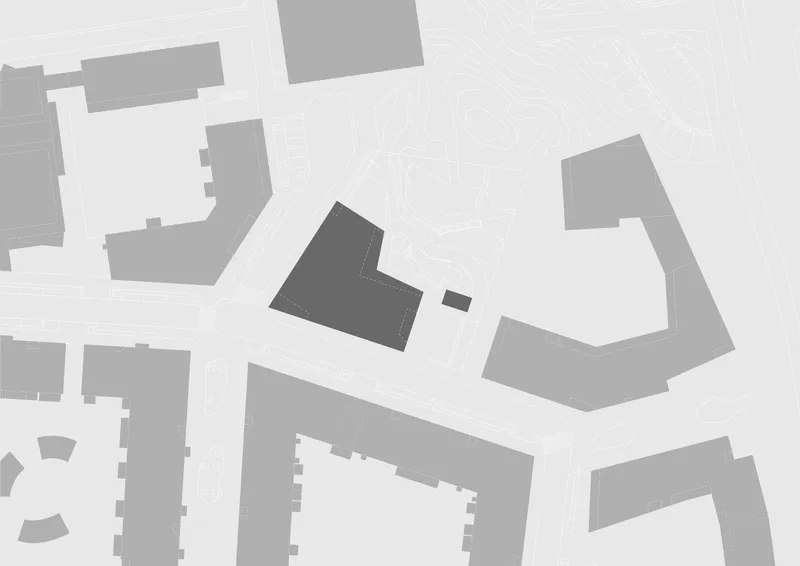 Site plan drawing showing an angled building footprint positioned among surrounding urban blocks