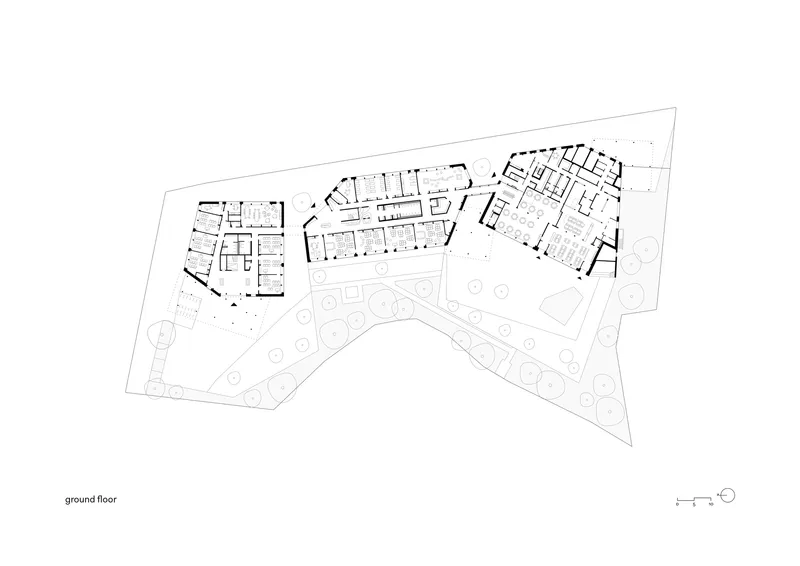 Ground floor plan drawing showing three angled wings arranged around a central outdoor space with circular tree plantings