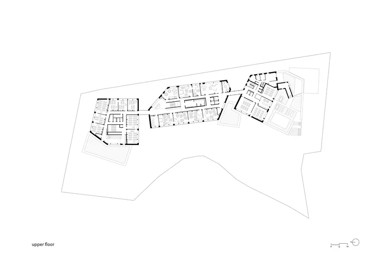 Upper floor plan drawing showing three connected wings with classroom layouts and circulation corridors