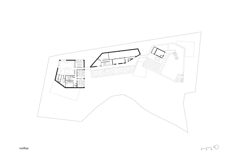 Rooftop plan drawing showing angular roof volumes with hatched auditorium seating area on one wing