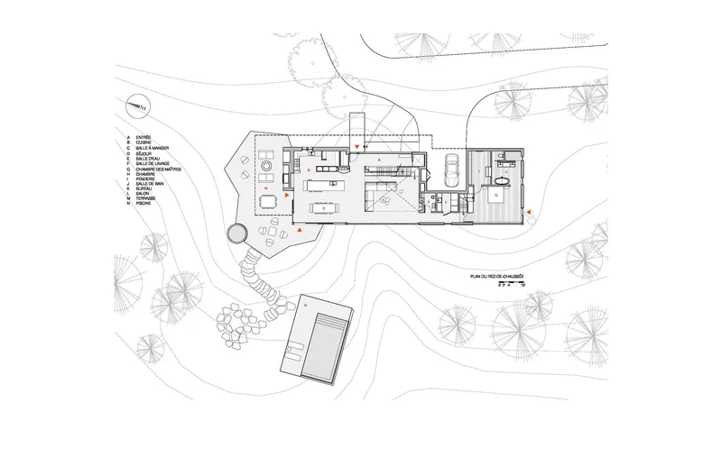 Site plan drawing depicting the main volume and detached structure within landscaped terrain and tree symbols