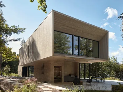 YH2 Architecture Stacks Two Wooden Blocks on a Rocky Outcrop Above Lake Memphremagog