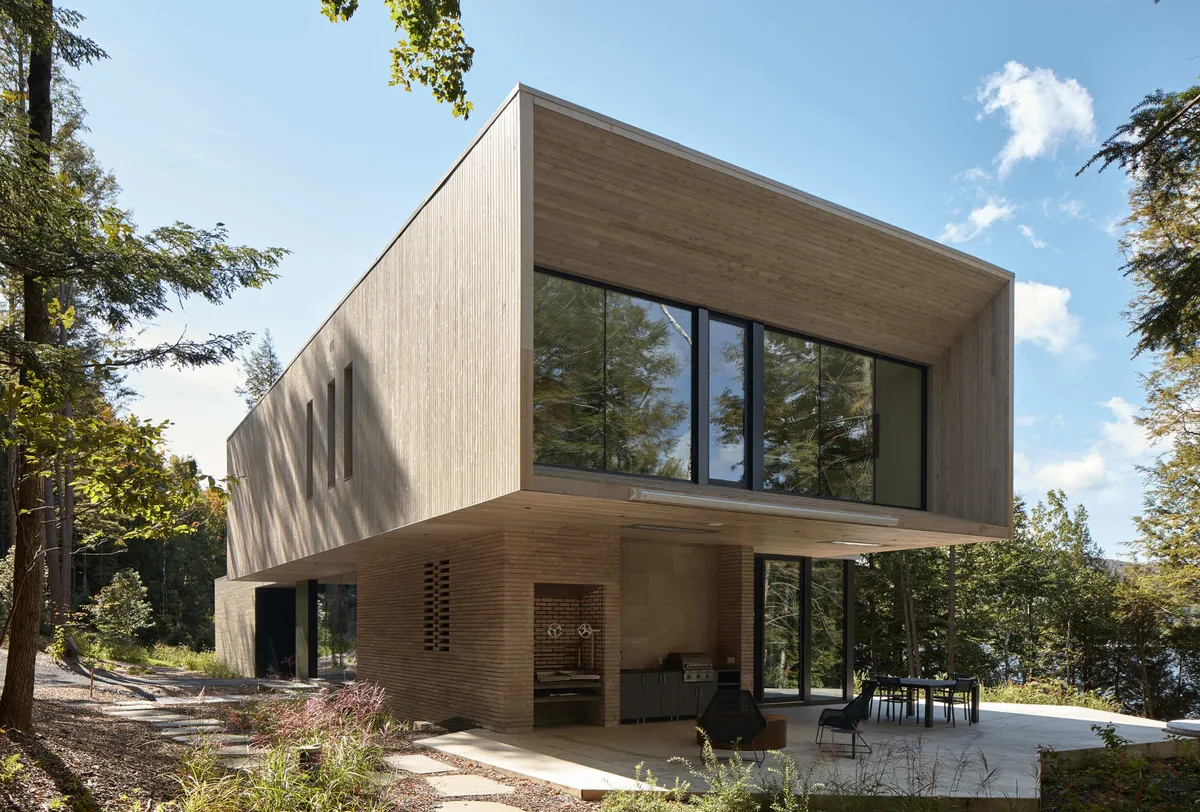 YH2 Architecture Stacks Two Wooden Blocks on a Rocky Outcrop Above Lake Memphremagog