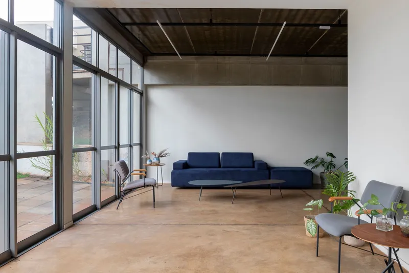 Open seating area with exposed concrete ceiling and full-height glazing to the terrace
