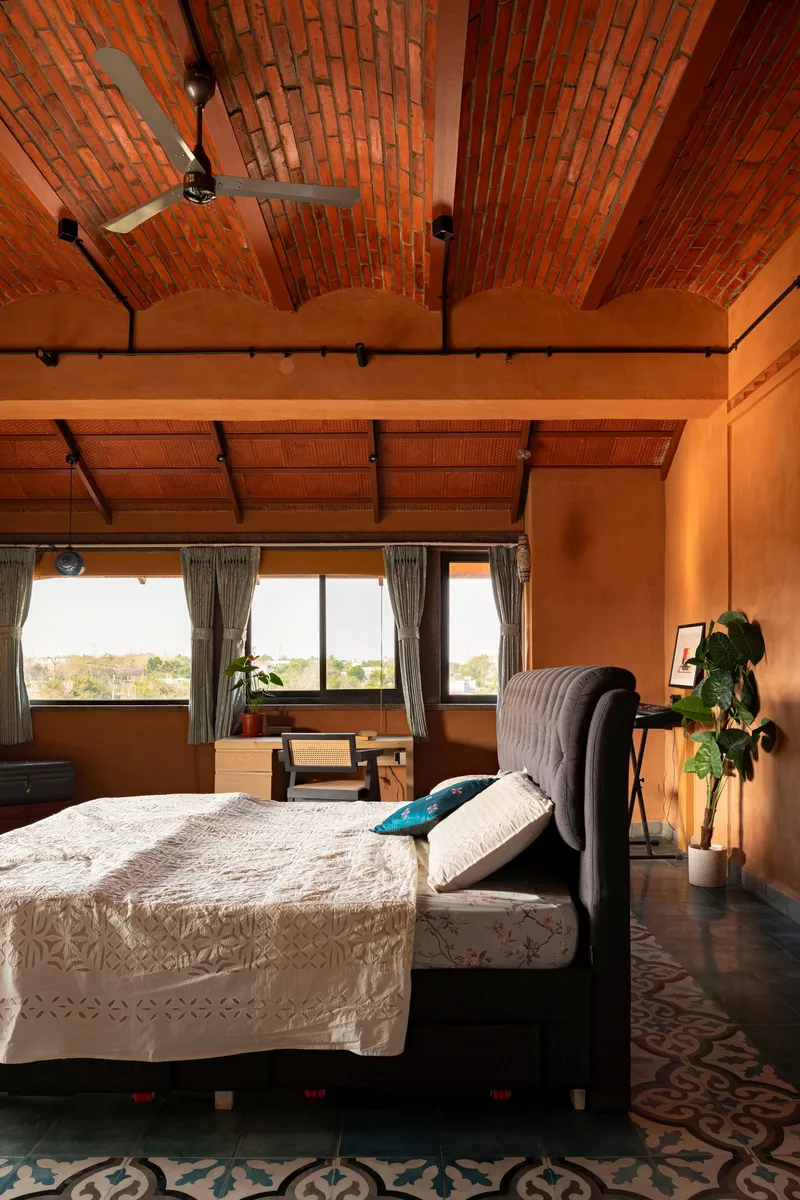 Bedroom with vaulted brick ceiling and horizontal ribbon windows framing distant landscape views