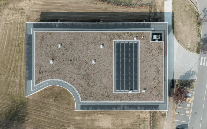 Aerial view of the gravel roof with four skylights and a rectangular solar panel array