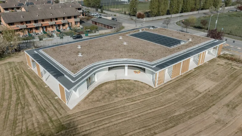 Aerial view of the gravel and solar panel roof with curved corner and surrounding agricultural fields