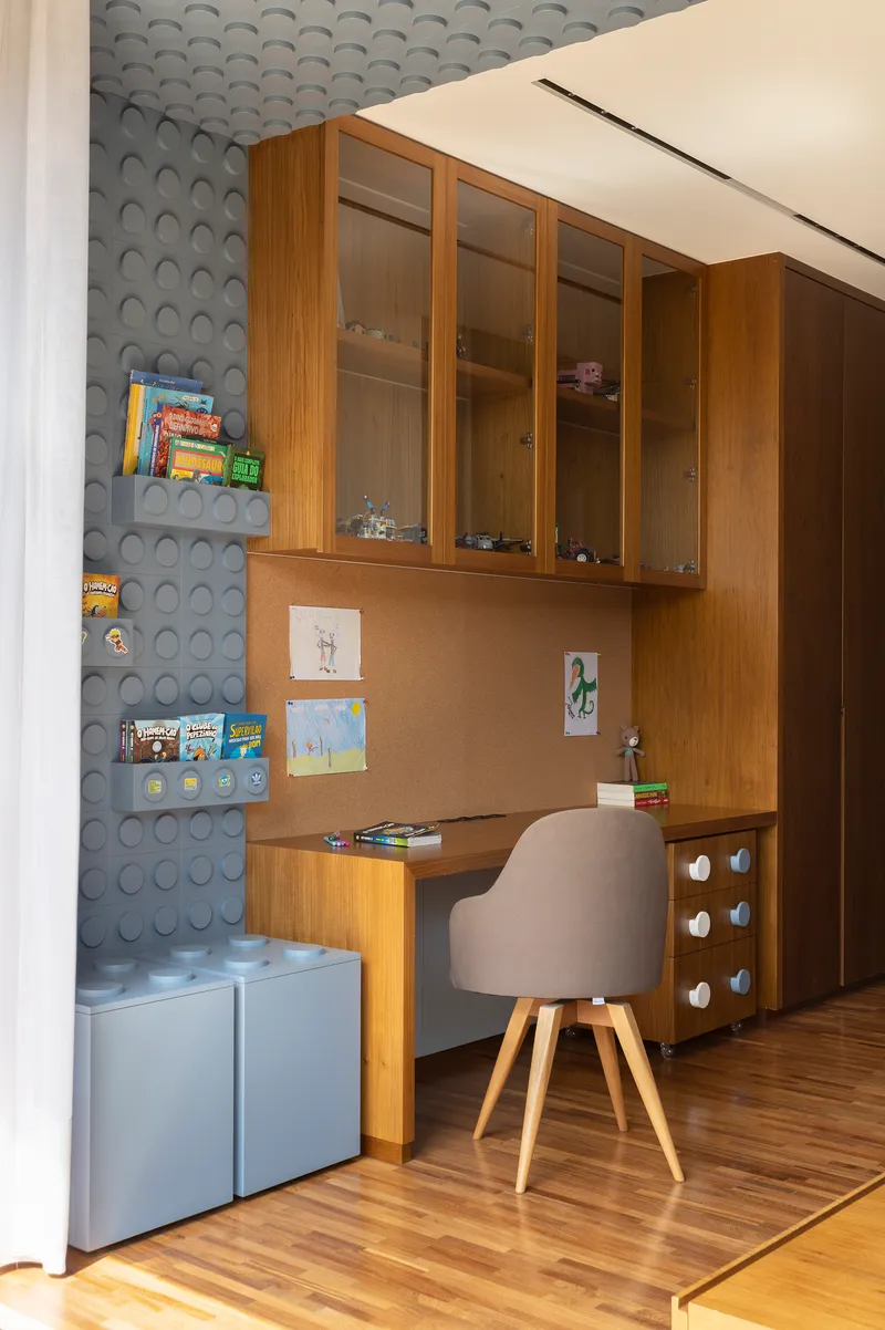 Built-in desk nook with timber cabinetry adjacent to a textured circular tile wall
