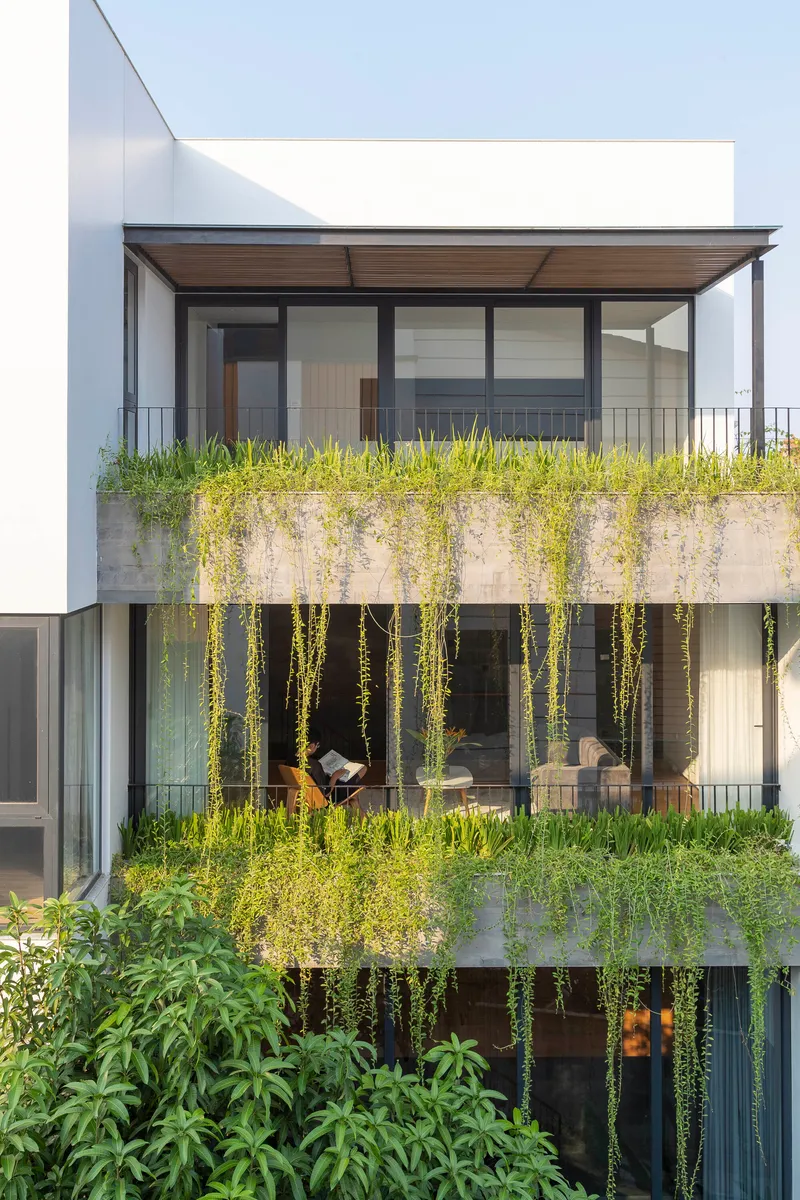 Garden facade with stacked concrete planters and cascading greenery spilling over multiple levels