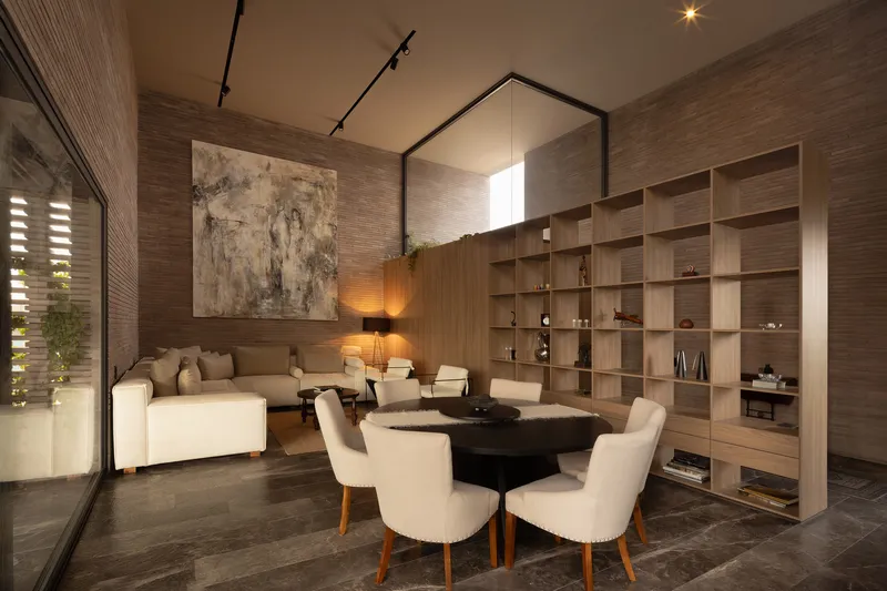 Double-height living room with horizontal timber wall cladding and built-in shelving beneath track lighting