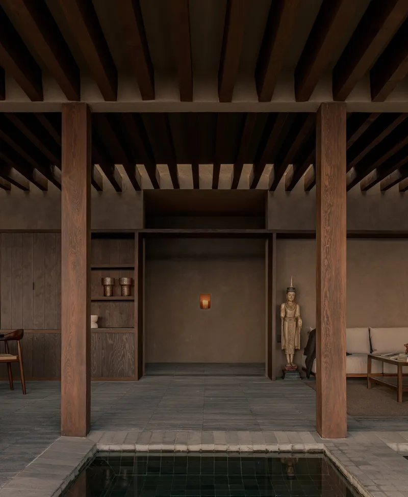 Closer view of the alcove with built-in shelves and a sculptural figure beside the pool edge
