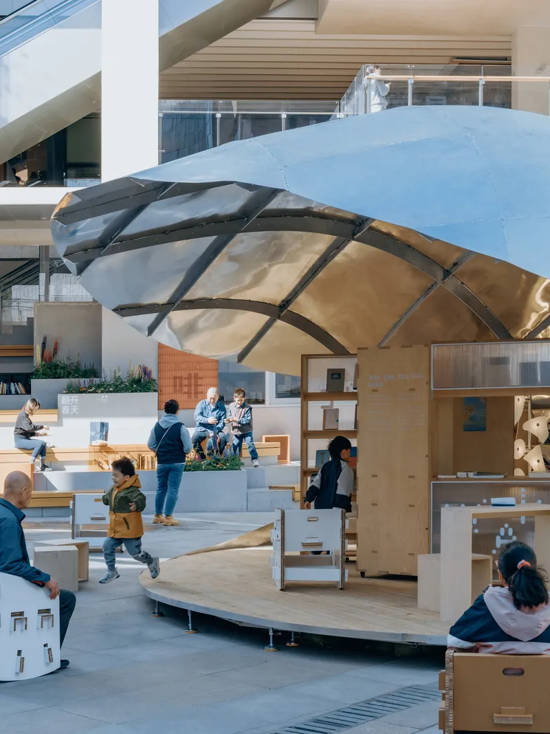 Interior view of the ribbed timber canopy sheltering stepped platforms and movable seating with visitors