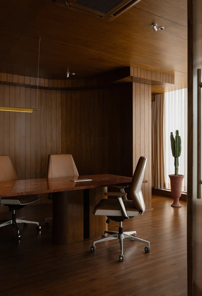 Dining area with timber wall paneling and linear pendant light above the table