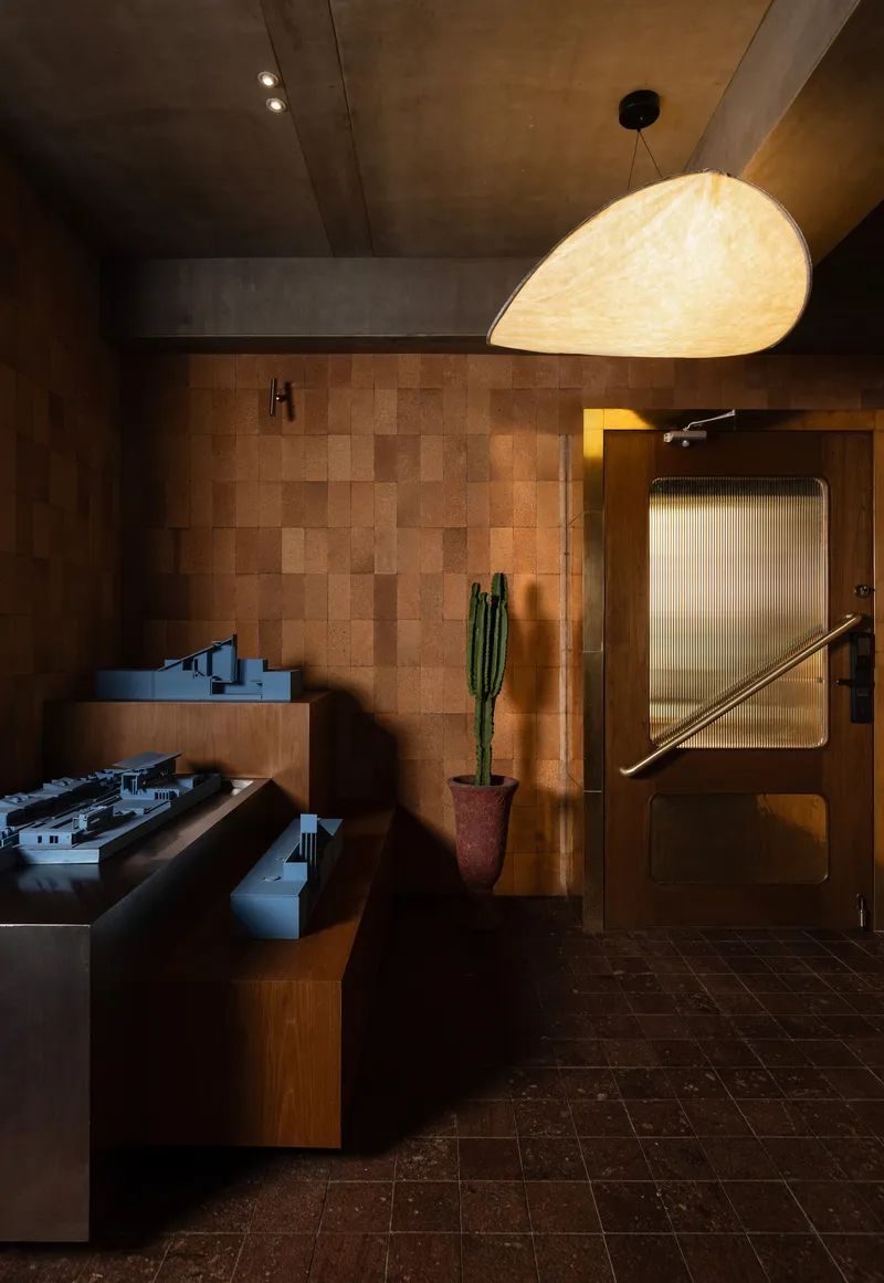 Kitchen with block-pattern timber wall and pendant light illuminating the cooking island at dusk