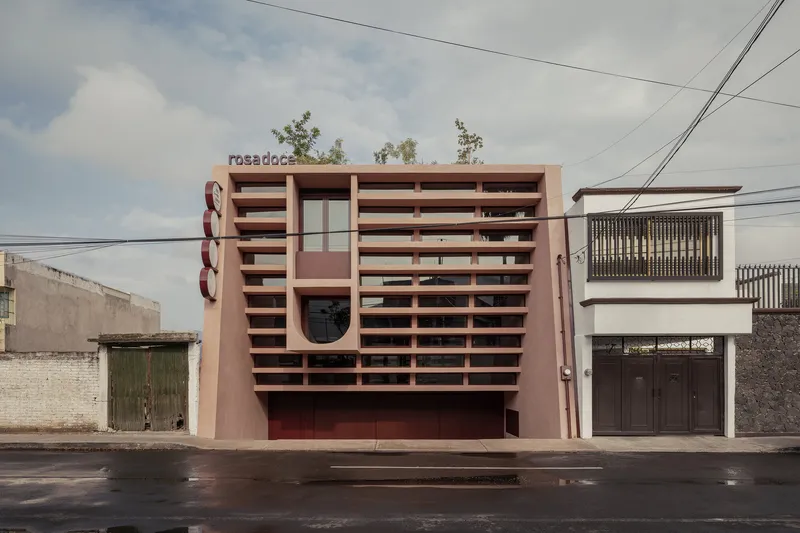 Street view of the horizontal brise-soleil facade in terracotta tones with overhead power lines