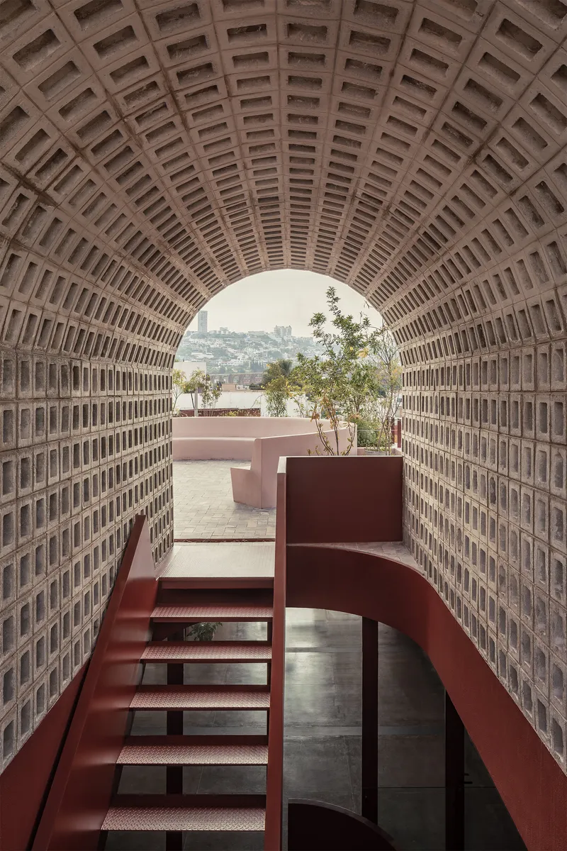 View through the vaulted brick tunnel opening to a planted terrace beyond