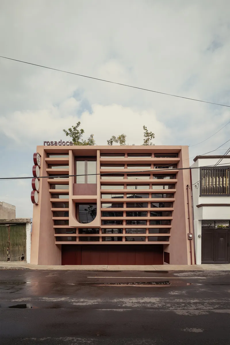 Frontal view of the layered facade screen with horizontal louvers under overcast skies