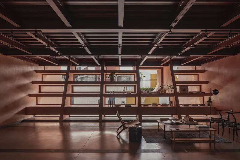 Open shelving unit with timber beams and exposed ceiling grid in afternoon light
