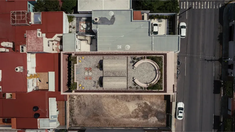Aerial view showing the narrow lot with circular vault structure and rectangular garden court between neighboring buildings