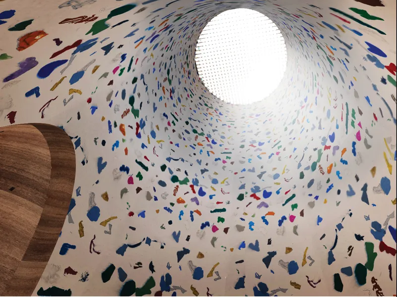 Interior light well animated by embedded plastic fragments, transforming waste into a spatial and atmospheric experience