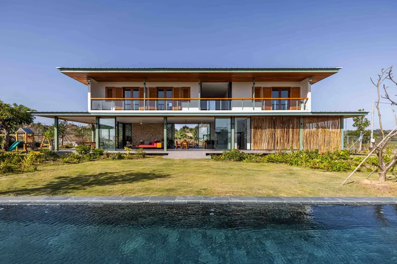 Two-story elevation across the reflecting pool showing open ground floor and enclosed upper balcony