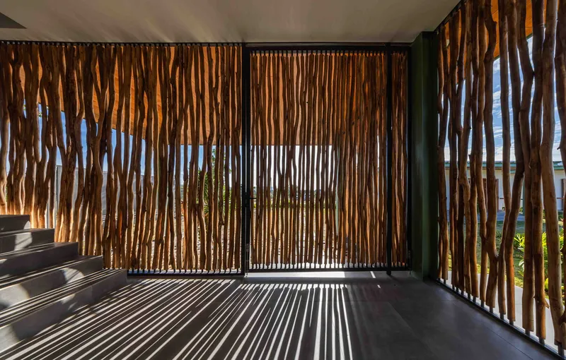 Curved timber slat screening wrapping the interior balcony with filtered views to greenery beyond
