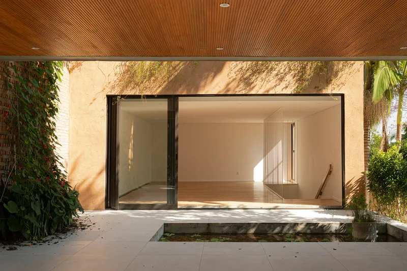 Covered terrace with timber slat ceiling and sliding glass doors opening to interior spaces