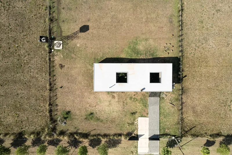 Drone view of the white rectangular roof with two square courtyards and adjacent water tower