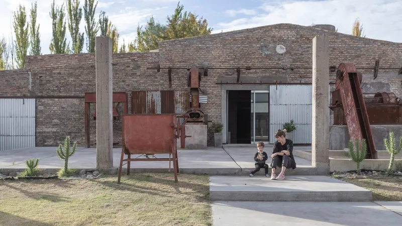 Courtyard view with exposed brick walls, concrete columns, corrugated metal cladding and rusted steel installations