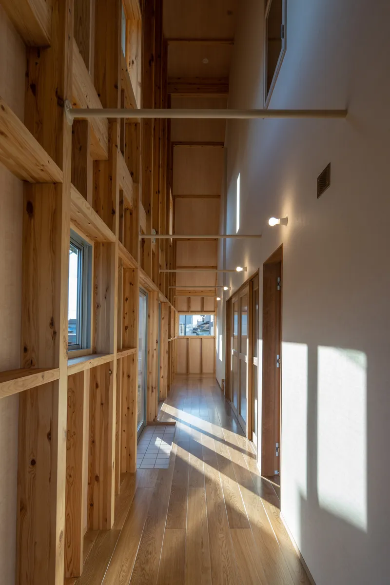 Corridor with timber stud walls and glazed openings flooding the space with natural light