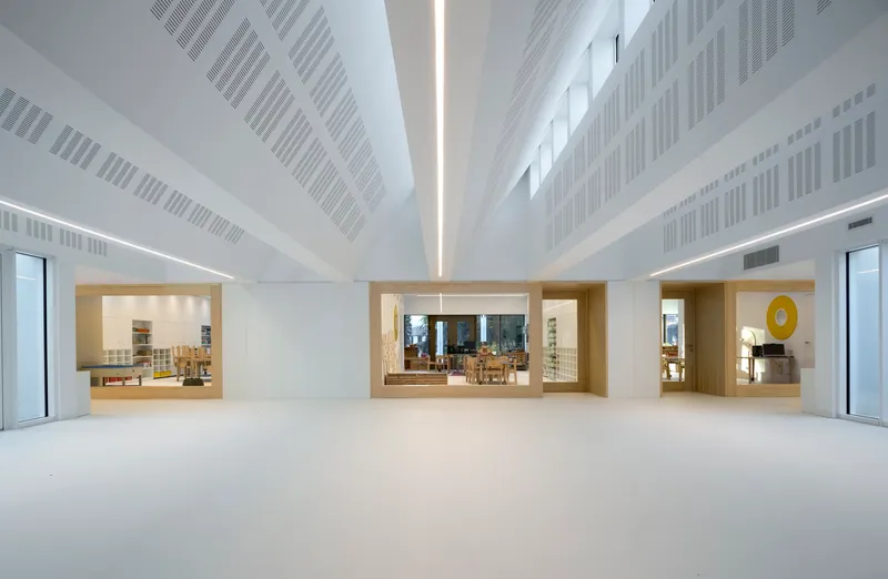 Central hall showing timber-framed openings to adjacent rooms beneath a sloped ceiling with linear vents