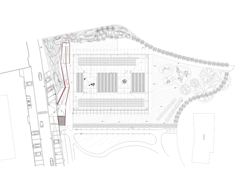 Site plan drawing showing rectangular structure with courtyard spaces and surrounding landscaped areas