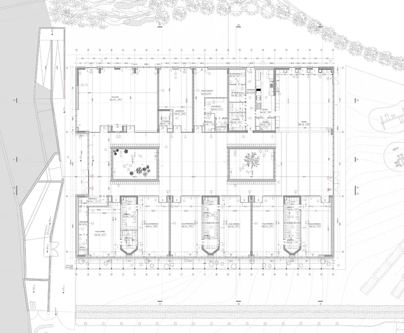 Floor plan drawing depicting rectangular building with two internal courtyards and symmetrical classroom wings