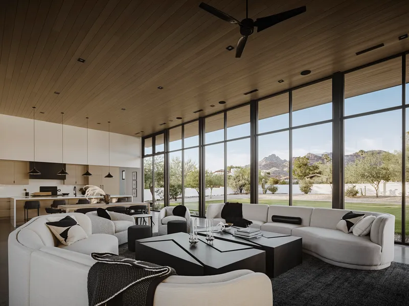 Living and kitchen area with wood-planked ceiling and full-height windows framing desert landscape