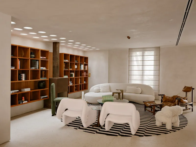 Living room with timber cubby shelving along one wall and a striped rug beneath recessed ceiling lights