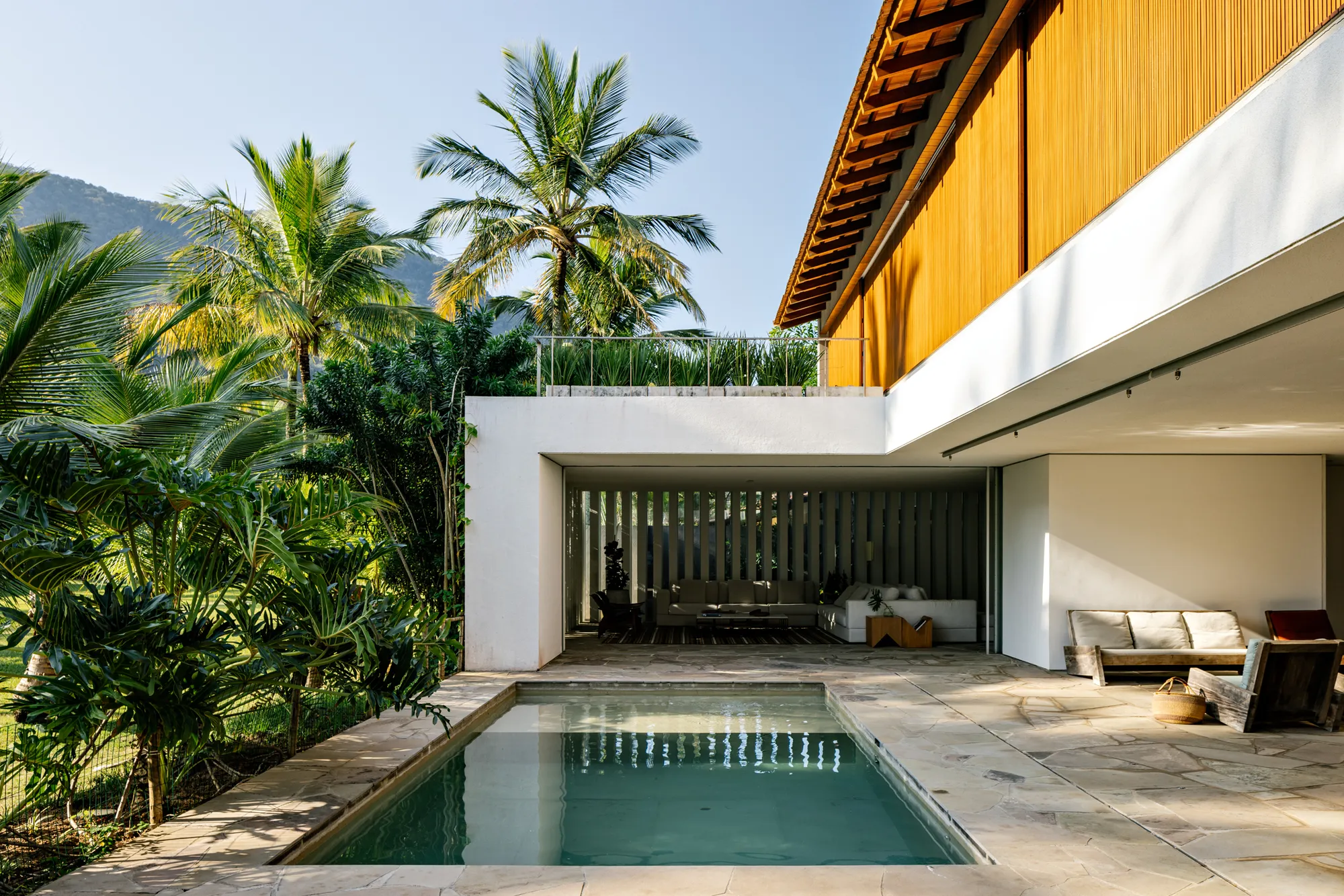 Gui Mattos Wraps a Coastal Family Home Around a Sunlit Pool Terrace in São Sebastião
