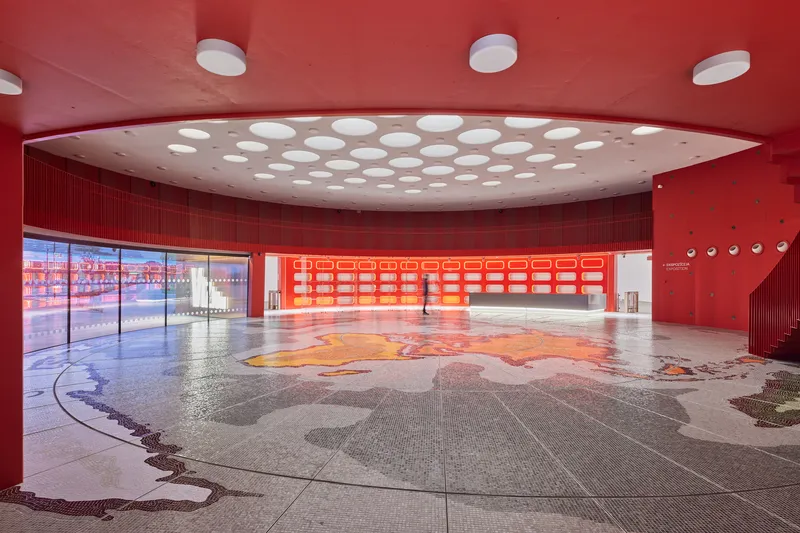 Entrance lobby with terrazzo floor inlay and circular skylights puncturing the curved red ceiling