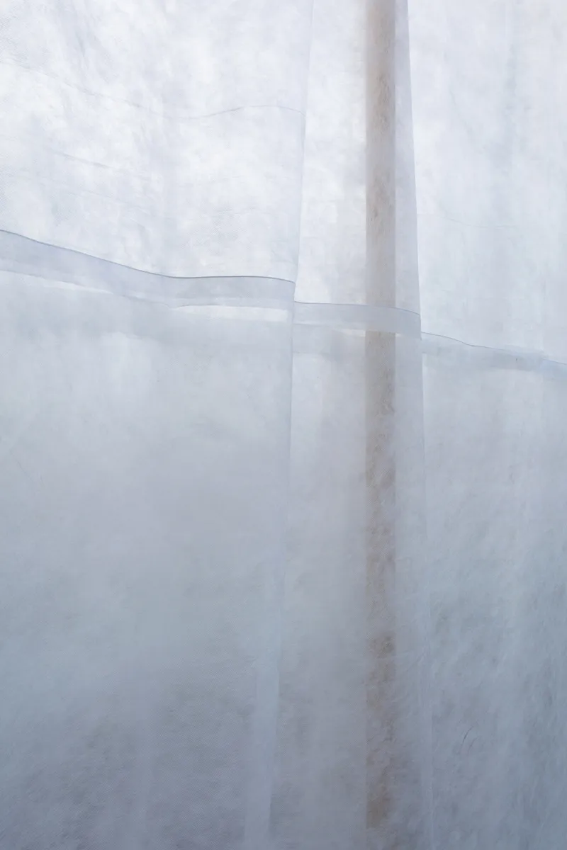 Close-up of overlapping translucent fabric panels showing seams and variations in texture