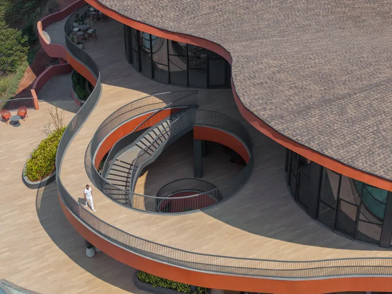 Top-down view of the circular spiral staircase connecting two levels of the curved terrace