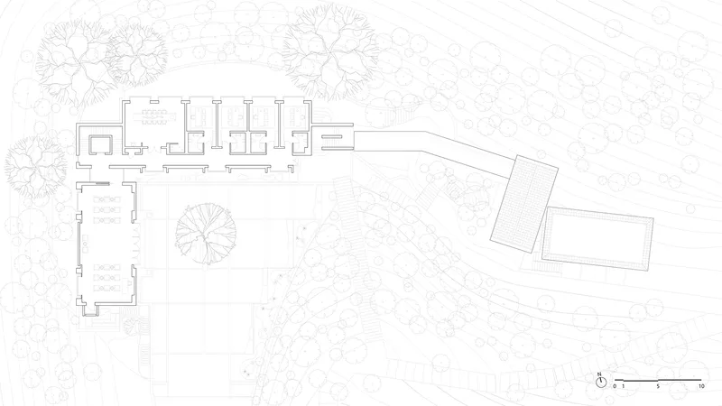 Site plan drawing showing the main residence, outbuildings, and surrounding tree canopies on sloping terrain