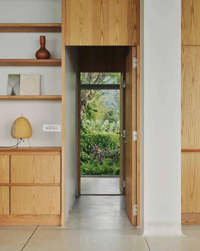 Narrow passageway framed by oak cabinetry leading to glazed door and garden beyond