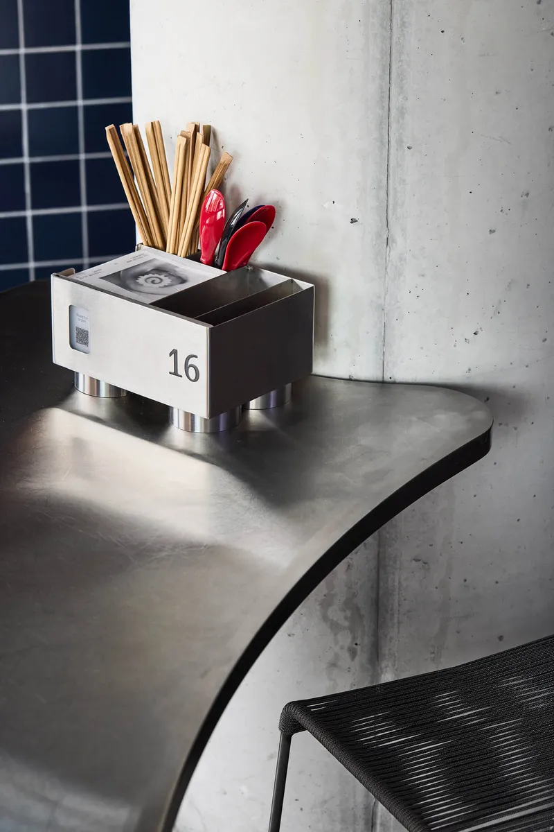 Numbered organizer box on curved countertop beside concrete column in afternoon light